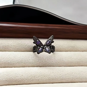 Macro shot of dark punk butterfly ring with purple gems in velvet jewelry box