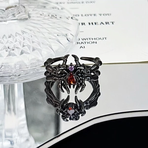 Macro shot of gothic spider ring with red drop-shaped stone and purple zircon detail