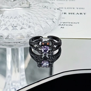 Gothic spider ring detail with purple heart stone and orange eyes on black metal