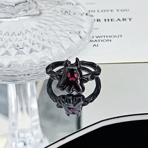 Detail view of a black punk ghost ring with red accents and a reflective surface