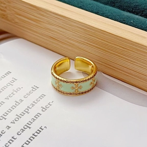 Macro d'une bague émaillée vert menthe avec motif croix dorée et bordure perlée