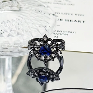 Detail of gothic black metal ring with a blue heart gemstone and silver diamonds