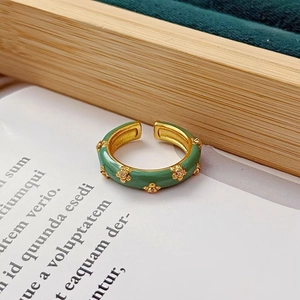 Détail de la bague fleur en émail vert menthe et plaqué or sur fond de velours