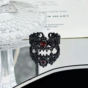 Gothic black carved ring with a vibrant red heart-shaped gemstone and intricate hollow patterns
