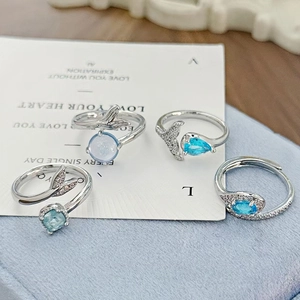 Detail of four mermaid tail rings with sea blue zircons in adjustable silver settings