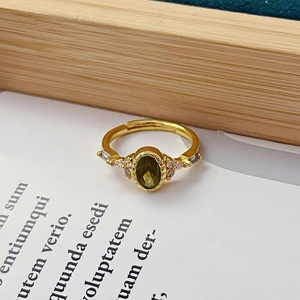 Gros plan d'une bague vintage plaquée or avec pierre verte et détails en zircon