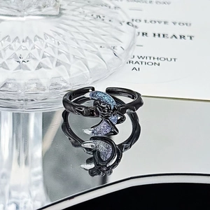 Macro view of dark punk crescent moon ring featuring a textured black vine band