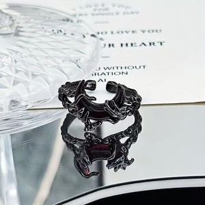Detail of gothic black crescent moon ring with vine textures on reflective surface