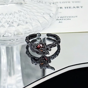 Detail of gothic ring with red faceted gemstone and dark wood texture finish
