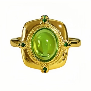 Bague vintage dorée avec grand cabochon ovale vert menthe et accents floraux sur blanc