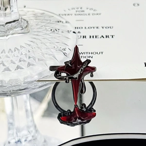 Macro detail view of a dark gothic punk red star ring with dripping enamel texture