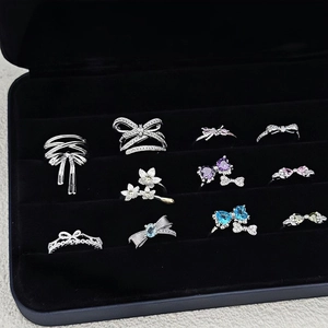 Minimalist bow rings set with colorful cubic zirconia on a black velvet jewelry box
