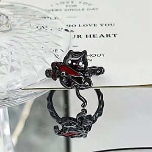 Macro detail of punk black cat ring with red dagger on reflective mirror surface