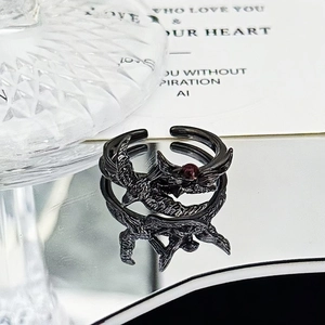 Detailed view of Gothic black raven ring with red gemstone and feather textures
