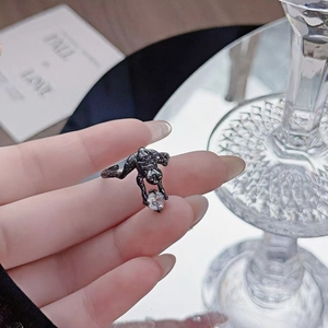 Detail of black cheetah ring grasping a sparkling round zircon stone on a finger