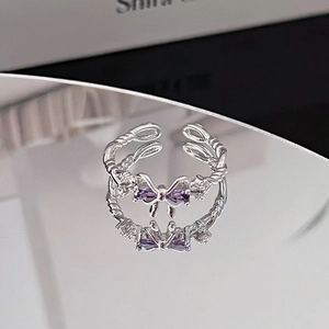 Macro shot of silver bow ring with purple cubic zirconia and twisted rope band