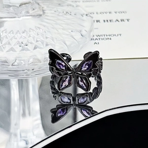 Macro detail of gothic butterfly ring with black plating and four purple marquise stones