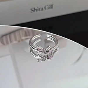 Macro shot of silver bow ring with pink marquise-cut stones and sparkling zircon details