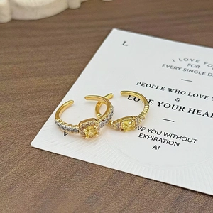 Nahaufnahme goldener Vintage-Ringe mit gelben Zirkonia-Steinen auf Display-Karte