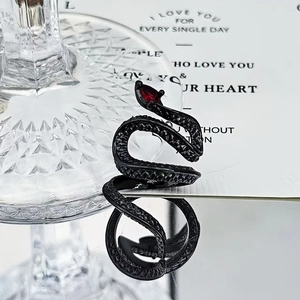 Detail of black gothic snake ring featuring red teardrop gemstone and scale texture