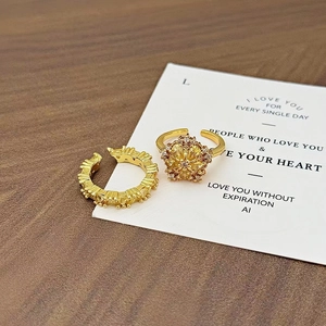 Detailansicht des goldenen Vintage-Ringes und Ohrklemmers auf dekorativer Karte