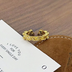 Makroaufnahme eines Vintage-Goldrings mit funkelnden Zirkonia im Quadrat- und Dreieckschnitt