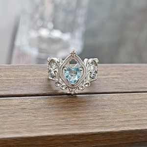 Macro view of Gothic crown ring with heart-shaped blue zircon and filigree silver band