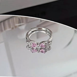Macro shot of silver bow ring featuring pink pear-cut gemstones and sparkling cubic zirconia