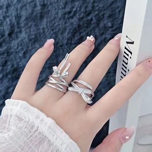 Detail shot of silver bow rings featuring sparkling zircon and polished ribbon design