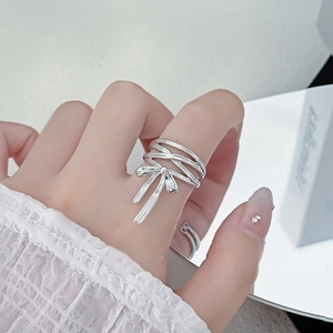Close-up of a silver bow knot multilayer ring with sparkling cubic zirconia on a finger