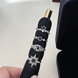 Detailed view of four silver stackable rings featuring moonstone and zircon on a black stand