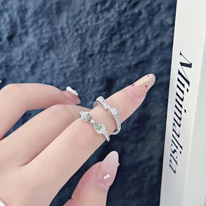 Minimalist silver bow rings set with green heart stones and sparkling cubic zirconia