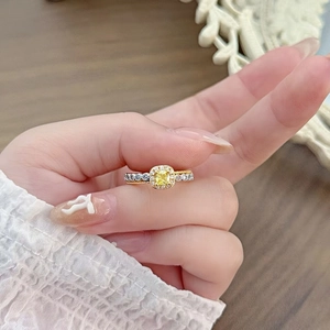 Makroansicht des goldenen Rings mit gelbem Edelstein und Pavé-Zirkon-Verzierung