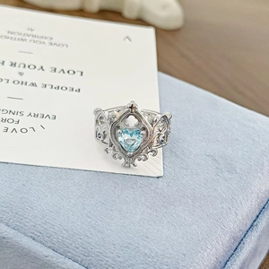 Detailed macro view of heart-shaped blue zircon on vintage open ring with hollow carvings