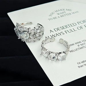 Detailed macro view of two silver adjustable zircon rings on a gift display