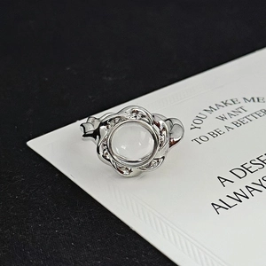 Detail of silver twisted ring featuring a moonstone center and delicate zircon accents