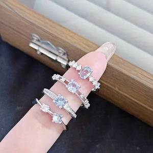Primer plano de un juego de anillos plateados con circonitas azul mar y blancas