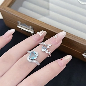 Detalle de anillo de circón azul corazón con acentos de cola de pez y micropavé de plata ley