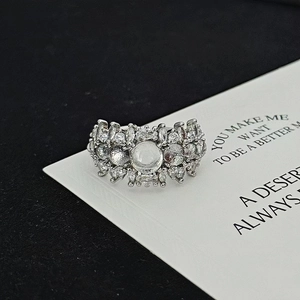 Close-up of a silver cocktail ring with shimmering moonstone and zircons on card
