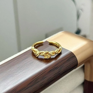 Dettaglio ravvicinato dell'anello dorato vintage a fiori con trama a vite e zirconi