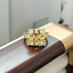Dettaglio ravvicinato di un anello a serpente vintage dorato con zirconi e pietre verdi
