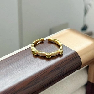 Dettaglio anello vintage dorato con fiori di trifoglio e finitura con trama spazzolata