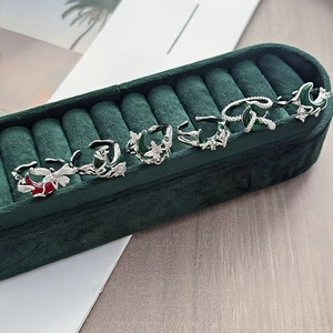 Dettaglio di anelli gotici in argento con luna in smalto verde e ali punk