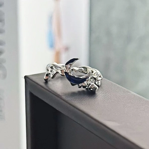 Dettaglio anello luna d'argento con smalto blu e texture di metallo liquido fluido