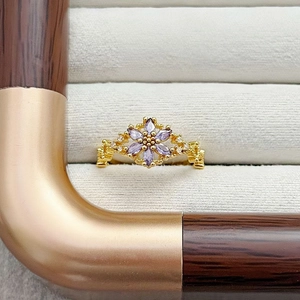 Makroaufnahme Goldring mit lila Markise-Edelsteinen und funkelnden weißen Diamanten
