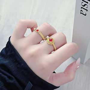 Nahaufnahme von Vintage-Goldringen mit roten Zirkonsteinen an einem Finger