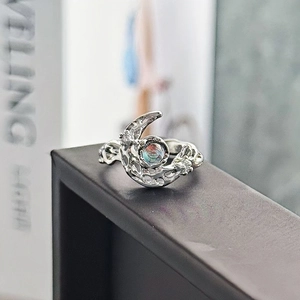 Dettaglio macro di anello a luna in argento con design a mezzaluna e gemma