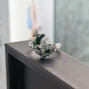 Dettaglio macro dell'anello lunare gotico con smalto verde e incisione di farfalla
