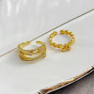 Details von goldfarbenen Stapelringen mit Zirkonia und zartem Schleifendesign