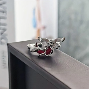 Dettaglio dell'anello gotico in argento con ali e intarsio rosso dal design raffinato